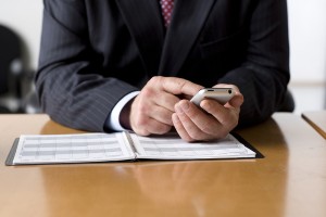 Businessman Checking His Schedule On Cell Phone.